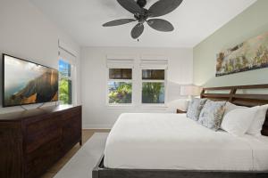 a bedroom with a bed and a ceiling fan at Pili Mai 5D condo in Koloa