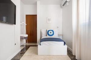 a small bedroom with a bed and a tv at Ocean Park 3BD 3BA Pool Walk to beach -Santorini123 in San Juan