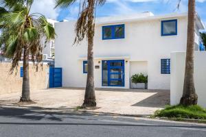a white house with blue doors and palm trees at Ocean Park 3BD 3BA Pool Walk to beach -Santorini123 in San Juan