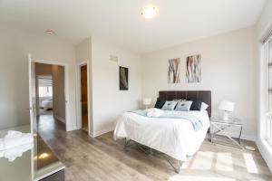 a white bedroom with a bed and a window at Luxury Comfort in Vaughan in Vaughan
