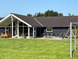 una casa con patio y parque infantil en 12 person holiday home in Idestrup-By Traum, en Bøtø By