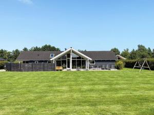 Una casa con un gran césped delante de ella. en 12 person holiday home in Idestrup-By Traum, en Bøtø By