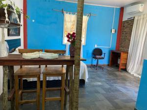 a blue room with a wooden table and stools at Refúgio mar aberto BA in Alcobaça +22 photos