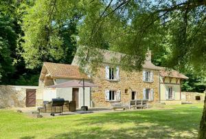 a stone house with a picnic table and an umbrella at gite de la faisanderie in La Chapelle-Rablais