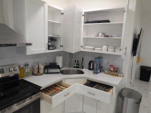 a kitchen with white cabinets and a sink at Modern Comfort - Minimal Style in Elmont