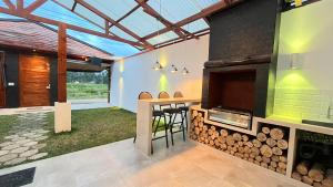 an outdoor kitchen with a fireplace and a table with stools at C4s4 RANCH OXAPAMPA in Oxapampa