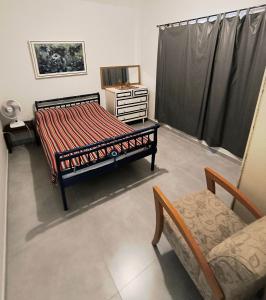 a bedroom with a bed and a table and a chair at Casa Praia do Centro Rio das Ostras 1 in Rio das Ostras