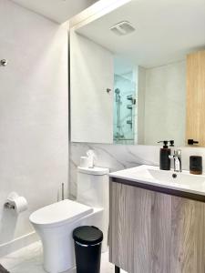 サントドミンゴにあるConfort y estilo en Galería 360 con piscina y gimnasioのトイレと洗面台を備えた白いバスルーム