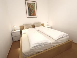 a bedroom with a large bed with white sheets at Apartment Katharina in Steinach am Brenner