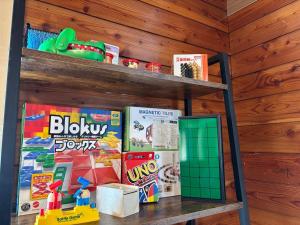 a shelf with toys and games on it at Lala's Riverside Cabin in Tsumagoi +58 photos