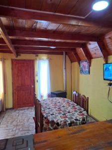 1 dormitorio con mesa y 1 cama en una habitación en Cabañas con Tinaja en Choshuenco, en Choshuenco