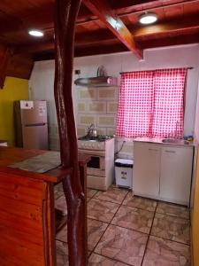 una cocina con estufa y refrigerador en Cabañas con Tinaja en Choshuenco, en Choshuenco