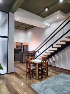 a dining room and kitchen with a table and stairs at FDH Apart in Posadas