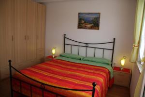 a bedroom with a bed with a red and orange blanket at Apartment Anethum in Premantura