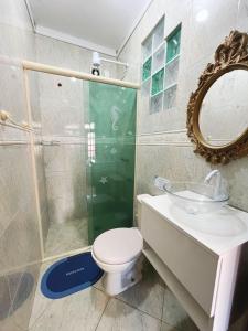 a bathroom with a toilet and a sink and a mirror at Casa com Piscina em Cabeçudas , 80 metros da Praia in Itajaí +5 photos