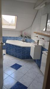 un bagno blu e bianco con vasca e lavandino di Family home near the city center! a Oudenbosch