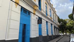 a building with blue and white doors on a street at General Hostel Belém in Belém