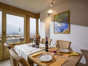 a dining room with a table and chairs with a window at - Chalet Panorama View in Kössen