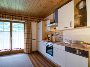 a kitchen with white cabinets and a sink at Holiday apartment with 2 bedrooms in Dorfgastein
