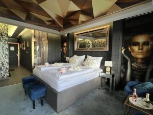 a bedroom with a large bed and a portrait of a woman at Luxury of togetherness in Zirkitz +36 photos