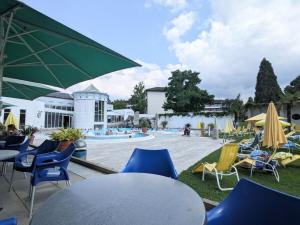 a group of chairs and tables with umbrellas and a pool at Holiday Home in Pfaffenweiler in Pfaffenweiler
