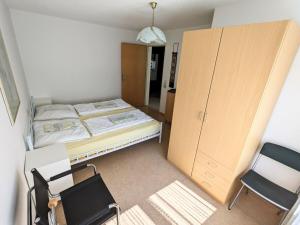 a small room with a bed and a cabinet and chairs at Holiday Home in Pfaffenweiler in Pfaffenweiler +30 photos