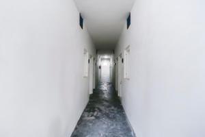 ein leerer Flur mit weißen Wänden und einem langen Gang in der Unterkunft Hotel O MCK Rooms in Rūpnagar