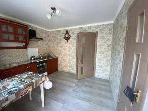 a kitchen with a stove and a table in it at Bugazik in Karolino-Buhaz
