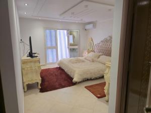 a bedroom with a bed and a television and a window at Villa de plage Sousse in Sousse