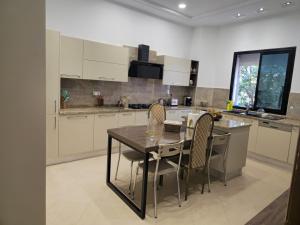 a kitchen with a table and chairs in it at Villa de plage Sousse in Sousse