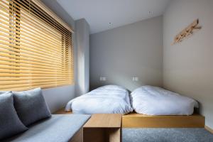 two beds sitting on a wooden bench in a bedroom at Yado Arashiyama -13 years old or older only- in Kyoto