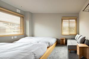a bedroom with two beds and a couch at Yado Arashiyama -13 years old or older only- in Kyoto