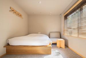 a bedroom with a white bed and a window at Yado Arashiyama -13 years old or older only- in Kyoto