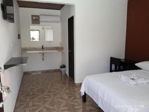 a bedroom with a bed and a sink in a room at Rancho de Sebas in Nicoya