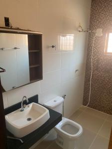 a bathroom with a sink and a toilet and a shower at Casa Bela Vista II in São Roque de Minas