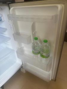 two bottles of water sitting inside of an open refrigerator at nearby umt unisza hosza litar gong badak airport chelong homestay kuala terengganu in Kampong Bukit Berangan