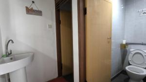 a bathroom with a toilet and a sink and a door at Natol Homestay - Kenyalang Park in Kuching +25 photos