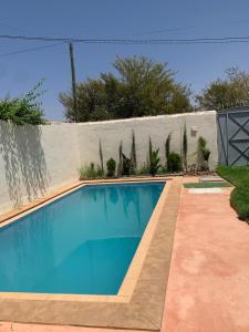 a blue swimming pool in front of a fence at paradis in Aït Bou Setta