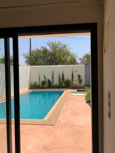 a view of a swimming pool through a sliding glass door at paradis in Aït Bou Setta