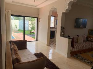 a living room with a couch and a tv at paradis in Aït Bou Setta +4 photos
