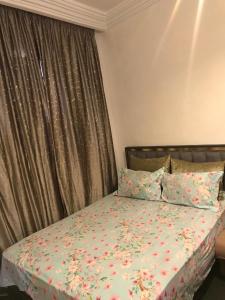 a bedroom with a bed with a floral bedspread at paradis in Aït Bou Setta