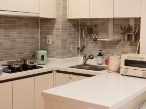 a kitchen with white cabinets and a stove top oven at Cozy Seomyeon House in Busan +13 photos