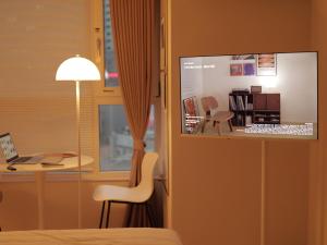 a room with a bed and a desk with a laptop at Cozy Seomyeon House in Busan