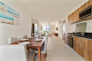 a kitchen with a wooden table and a dining room at Casa Akumal Caribbean Sea Views Walk To Beach 11 Pools in Akumal