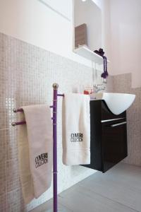 łazienka z umywalką i ręcznikami na wieszaku na ręczniki w obiekcie B&B Favola Mediterranea w Katanii