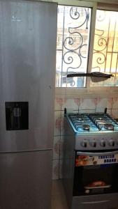 a kitchen with a stainless steel stove and a window at Sacha studio chic etoug ebe in Yaoundé +2 photos