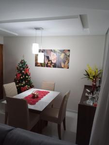 a dining room with a table and a christmas tree at Quarto em apartamento no cabula in Salvador