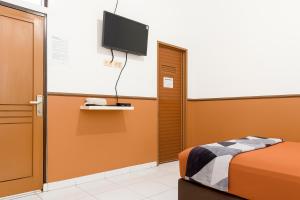 a room with a bed and a flat screen tv at Citytel Kostel in Lampung