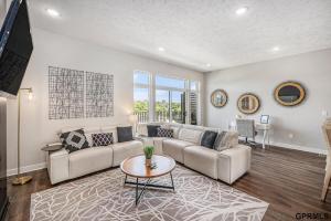 a living room with a couch and a table at Modern 3-Story Townhome in Omaha