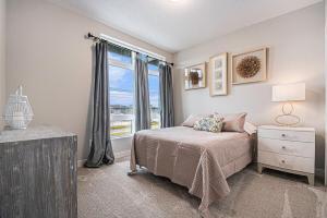 a bedroom with a bed and a window at Modern 3-Story Townhome in Omaha